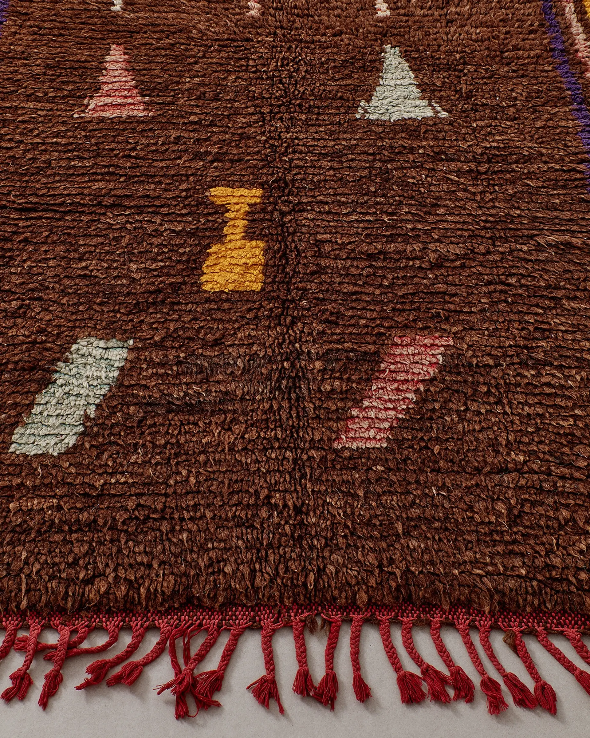 Brown rug with small pastel pictograms