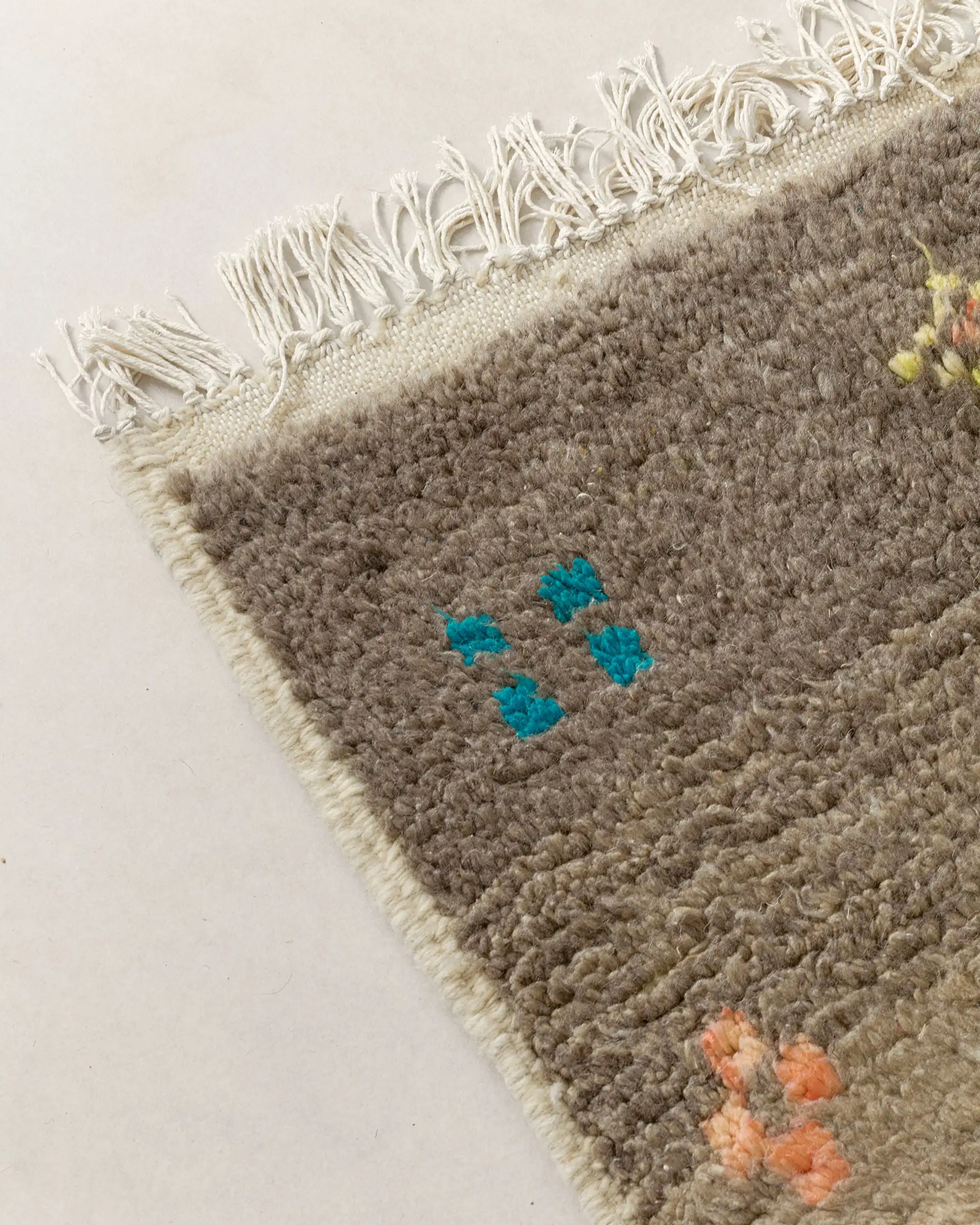 Grey rug w multicolour motifs, fringes